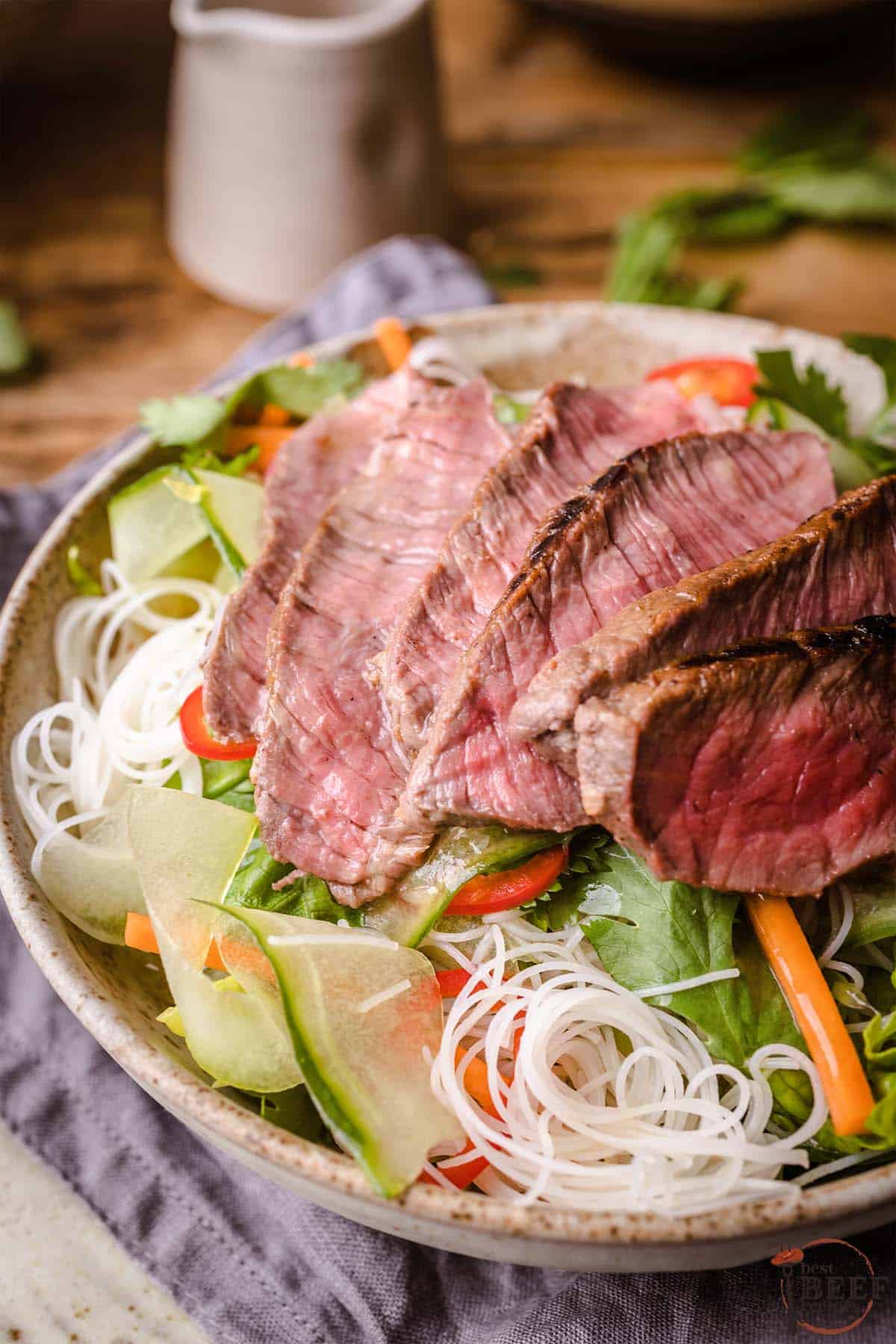 Vietnamese beef salad in a bowl with rice noodles and thinly sliced steak