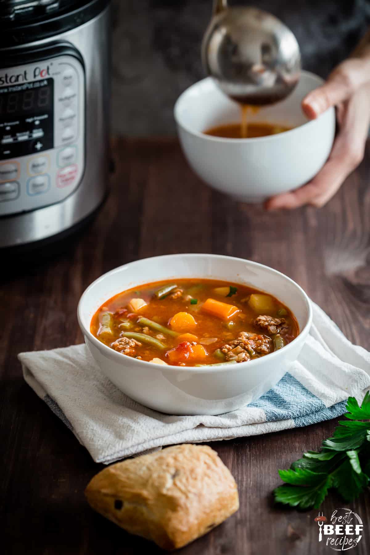 Instant Pot hamburger Soup being ladled into a white bowl