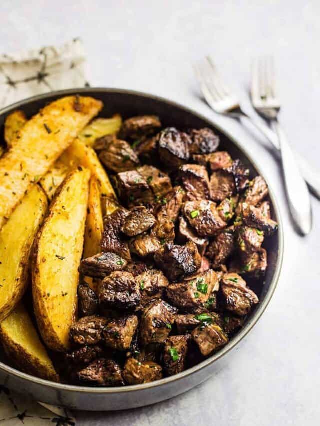 Steak Bites served with potato wedges in a bowl.