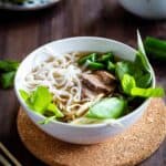 Close up of beef pho in a white bowl