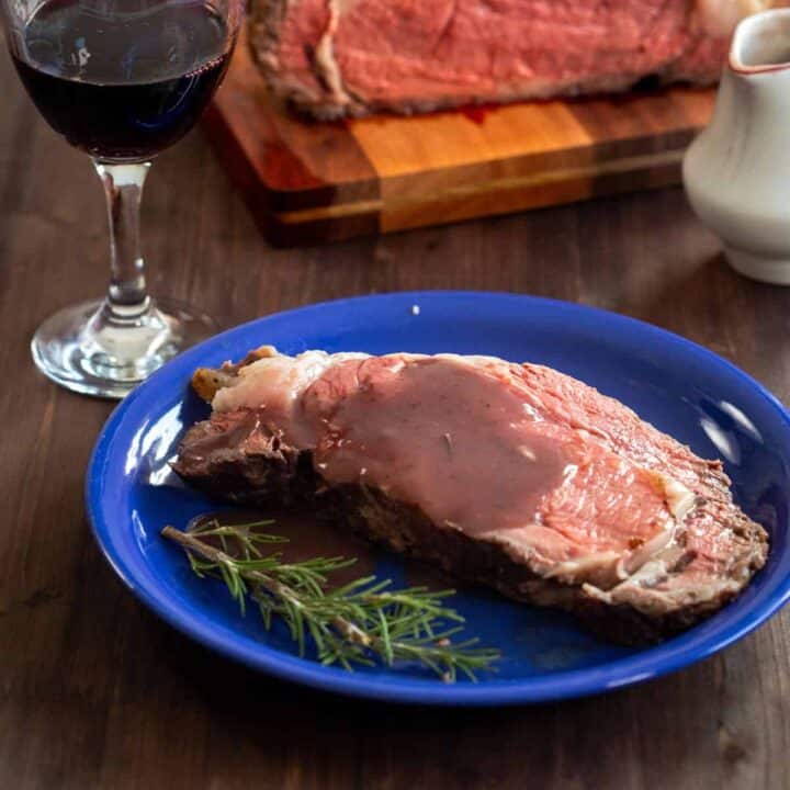 A slice of prime rib in the instant pot with a glass of wine and gravy