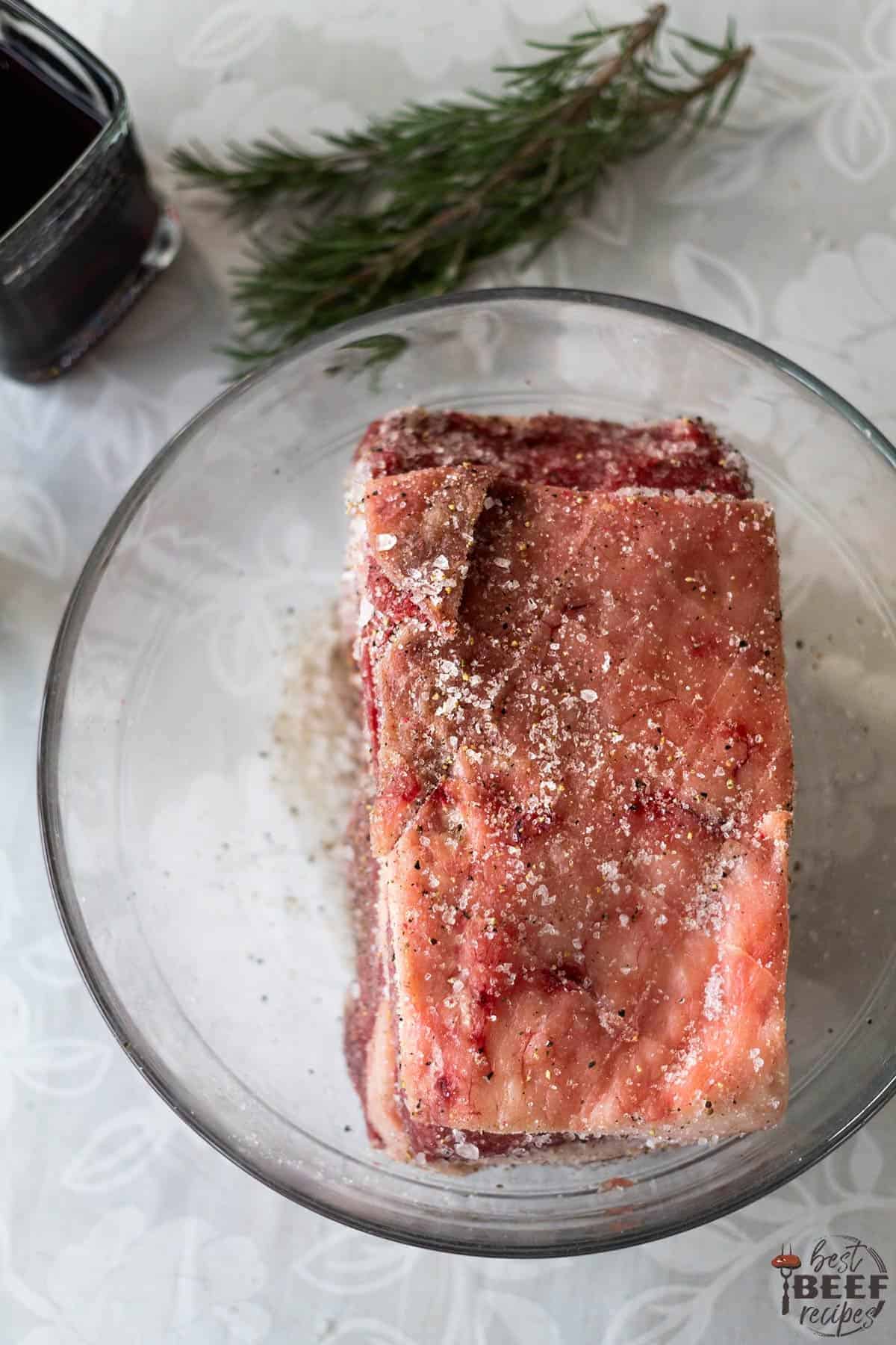 Raw prime rib in a glass bowl for Instant Pot Prime Rib