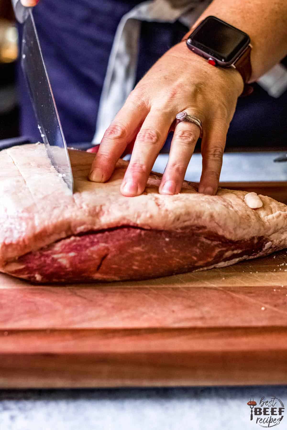 Scoring the fat cap of sirloin cap steak