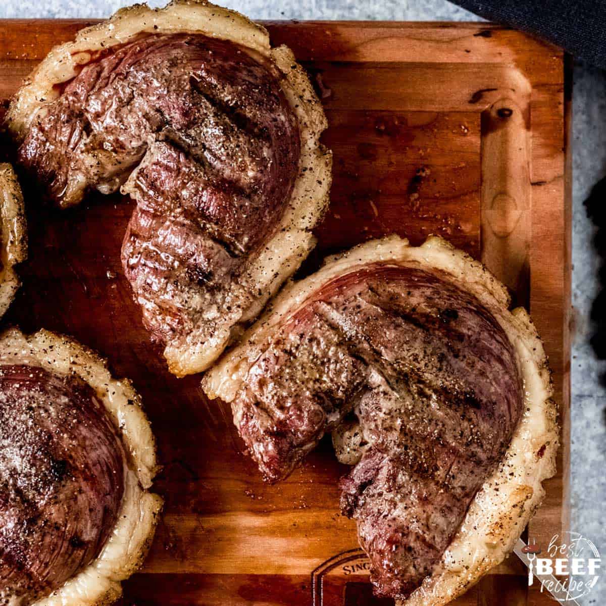 Two cuts of grilled Picanha steak on a skewer