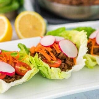 Line of three Portuguese beef lettuce wraps on a white plate
