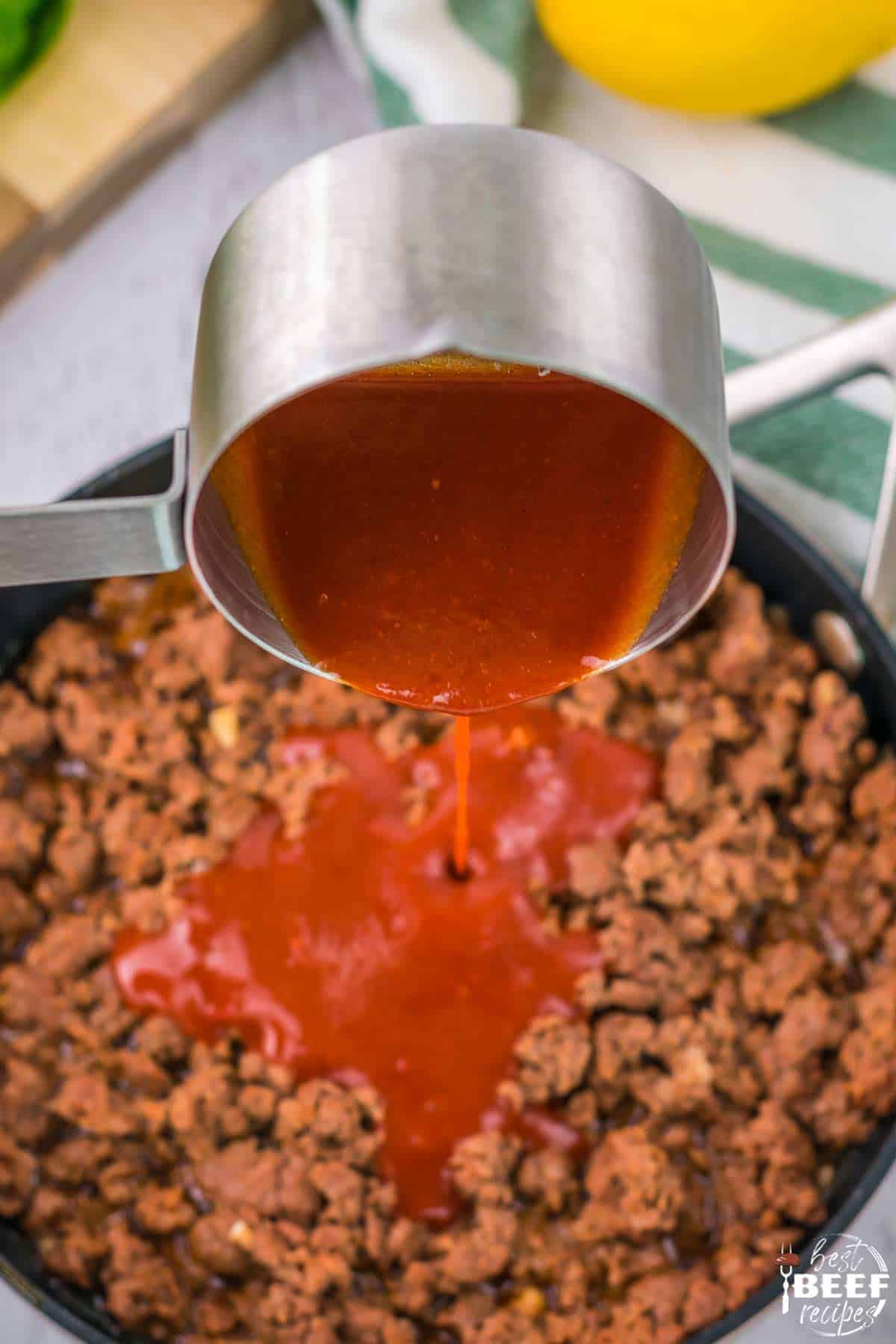 Ladling in peri-peri sauce to beef mixture