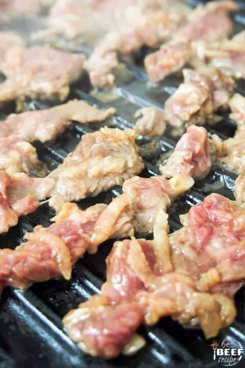 Close up of sliced ribeye on a grill pan for Korean beef bulgogi bowl recipe