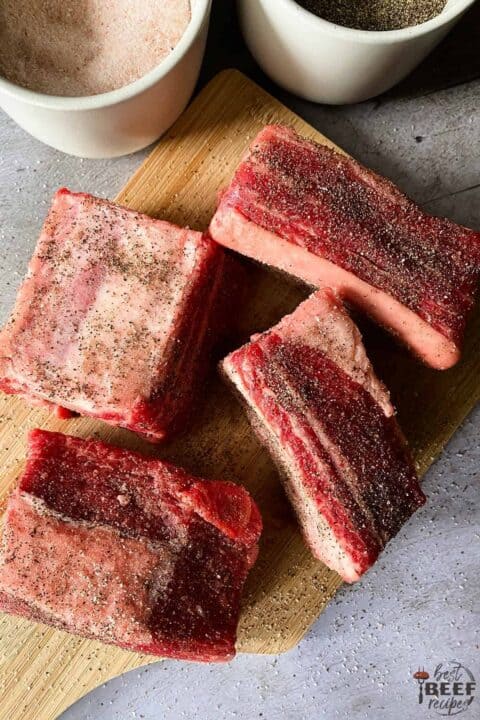 Seasoned beef ribs on a cutting board