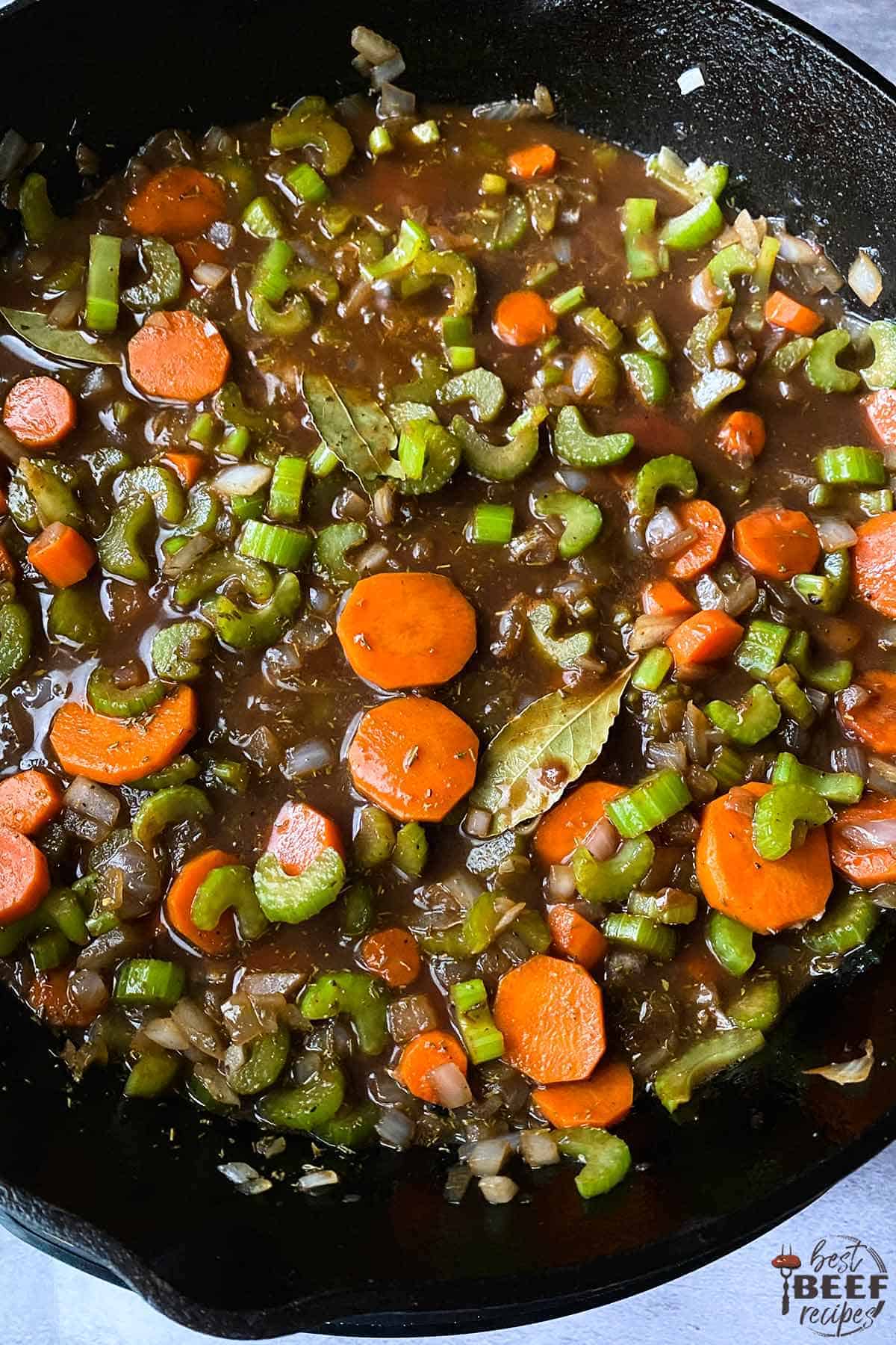 Adding liquid to skillet with vegetables for slow cooker beef ribs