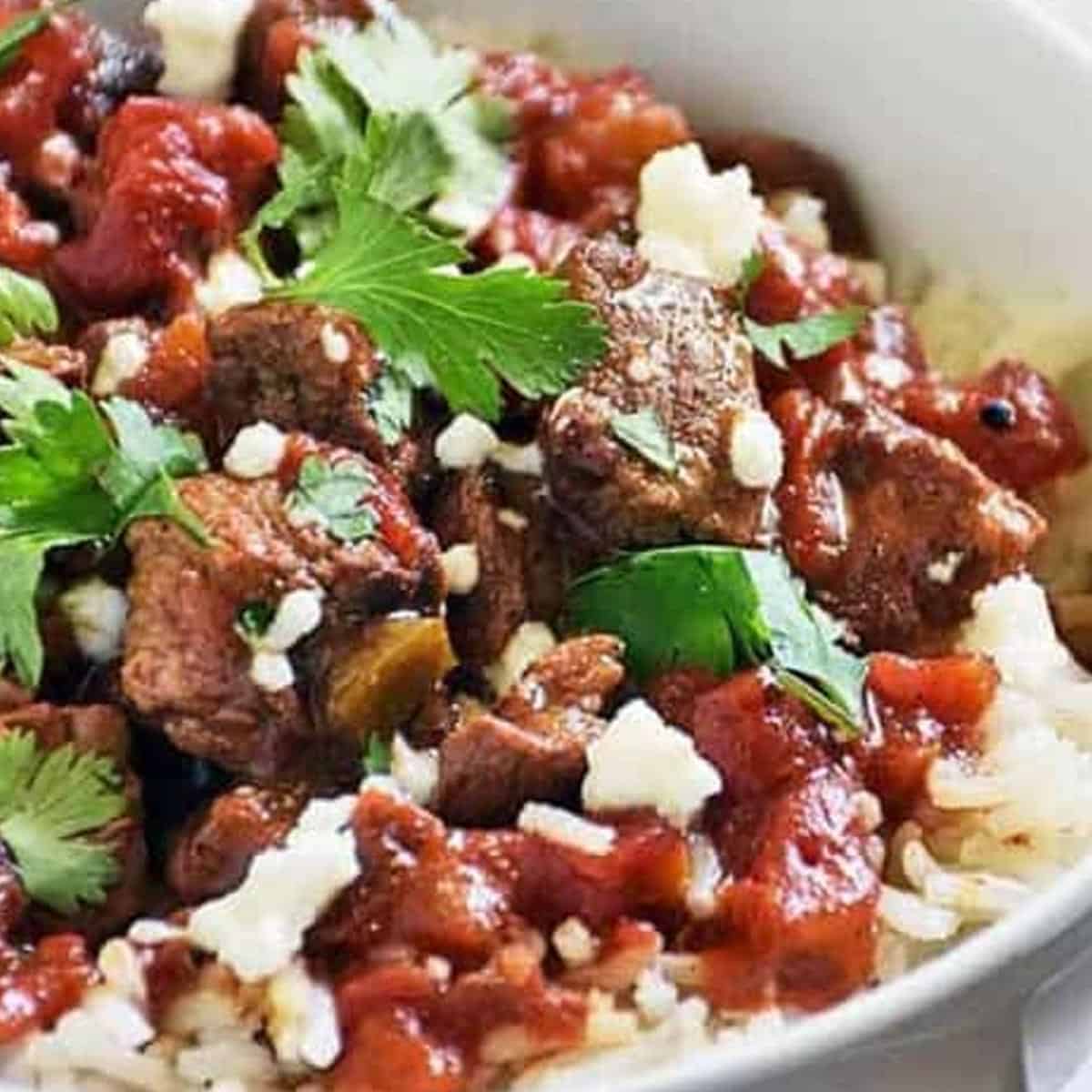 carne picada up close in a white bowl with cilantro on top