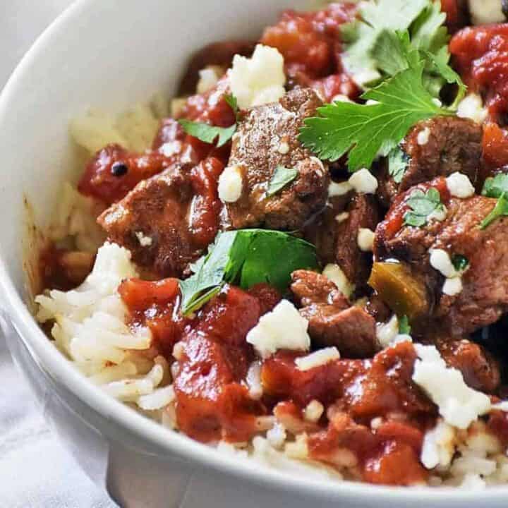Close up of carne picada in a bowl served with rice and cilantro