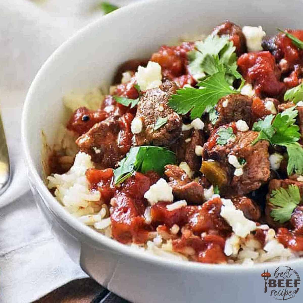 Close up of carne picada in a white bowl with cilantro and rice