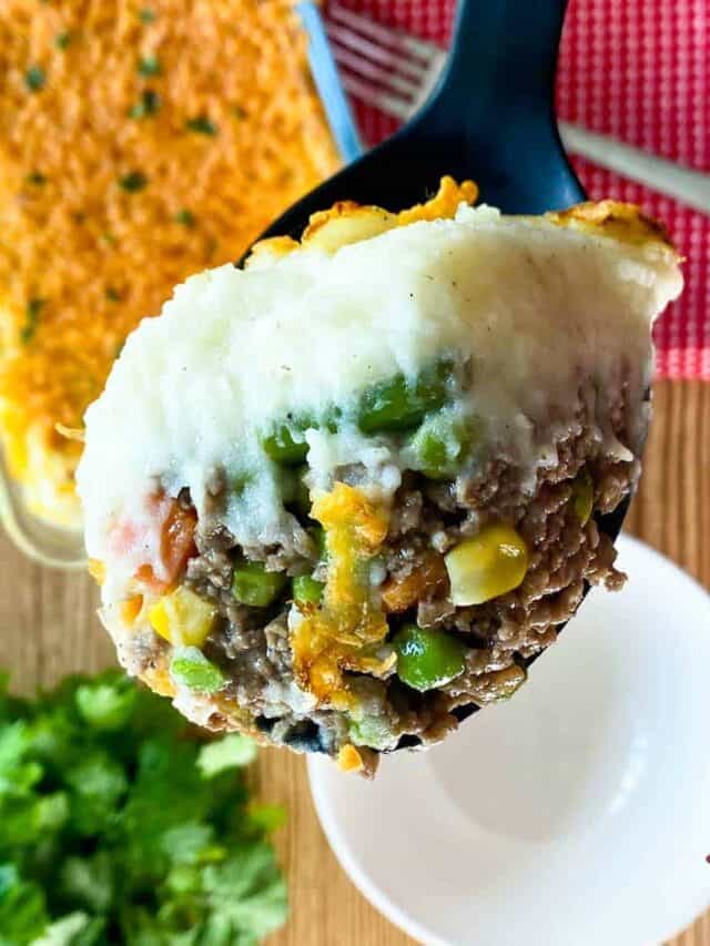 Close up of a spoonful of Instant Pot Shepherd's Pie over a white bowl