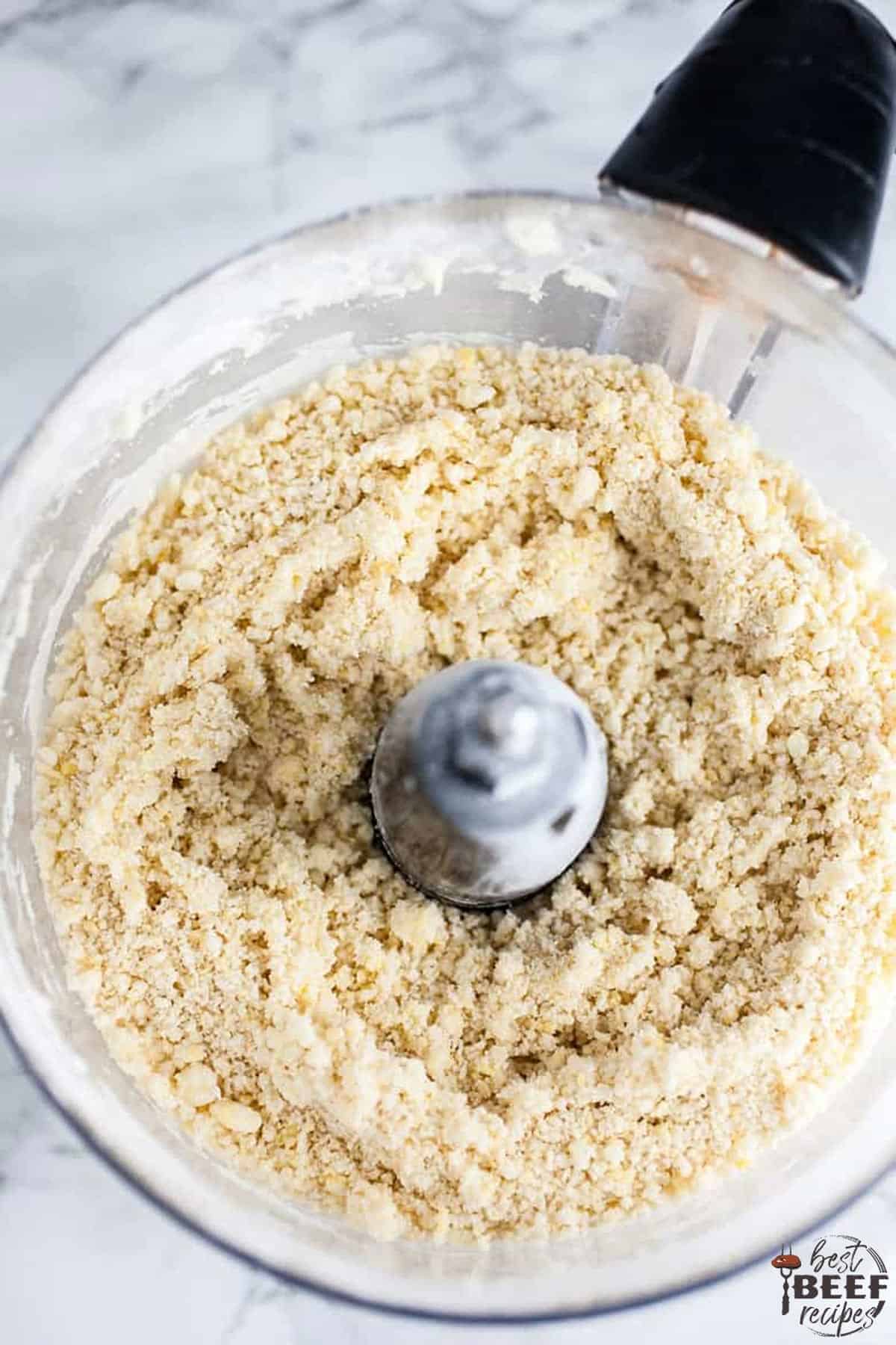 mixing the empanada dough in a food processor