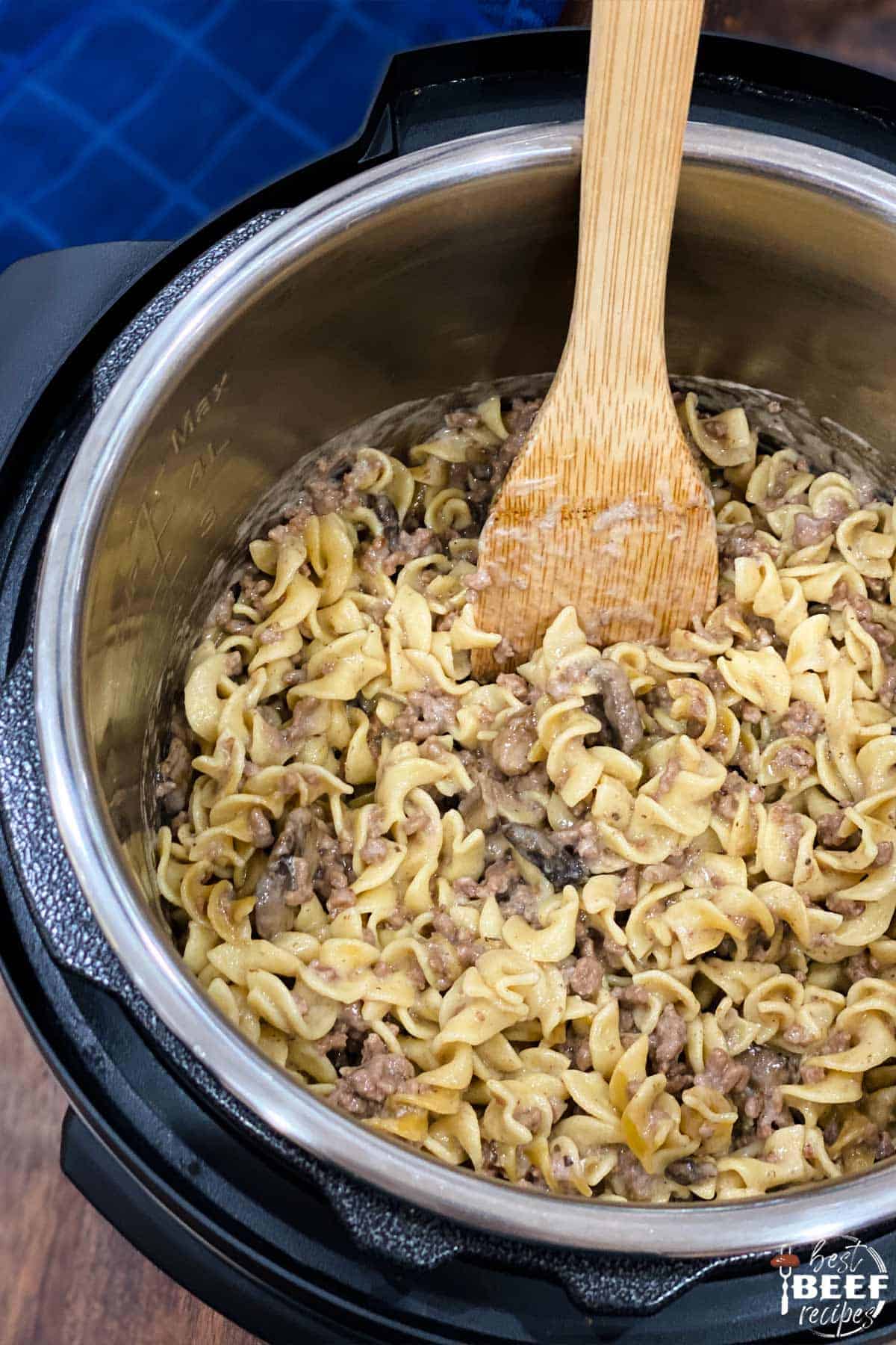 Instant pot beef stroganoff in the pot with a wooden spoon