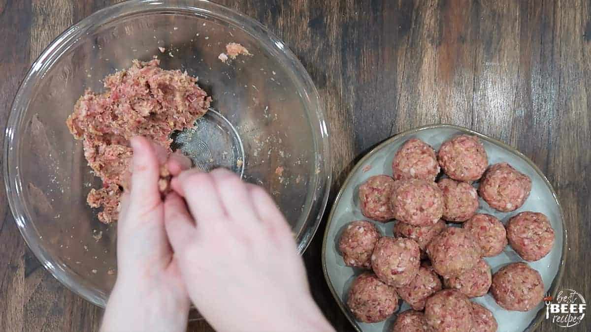 Rolling instant pot meatballs next to a plate of rolled meatballs