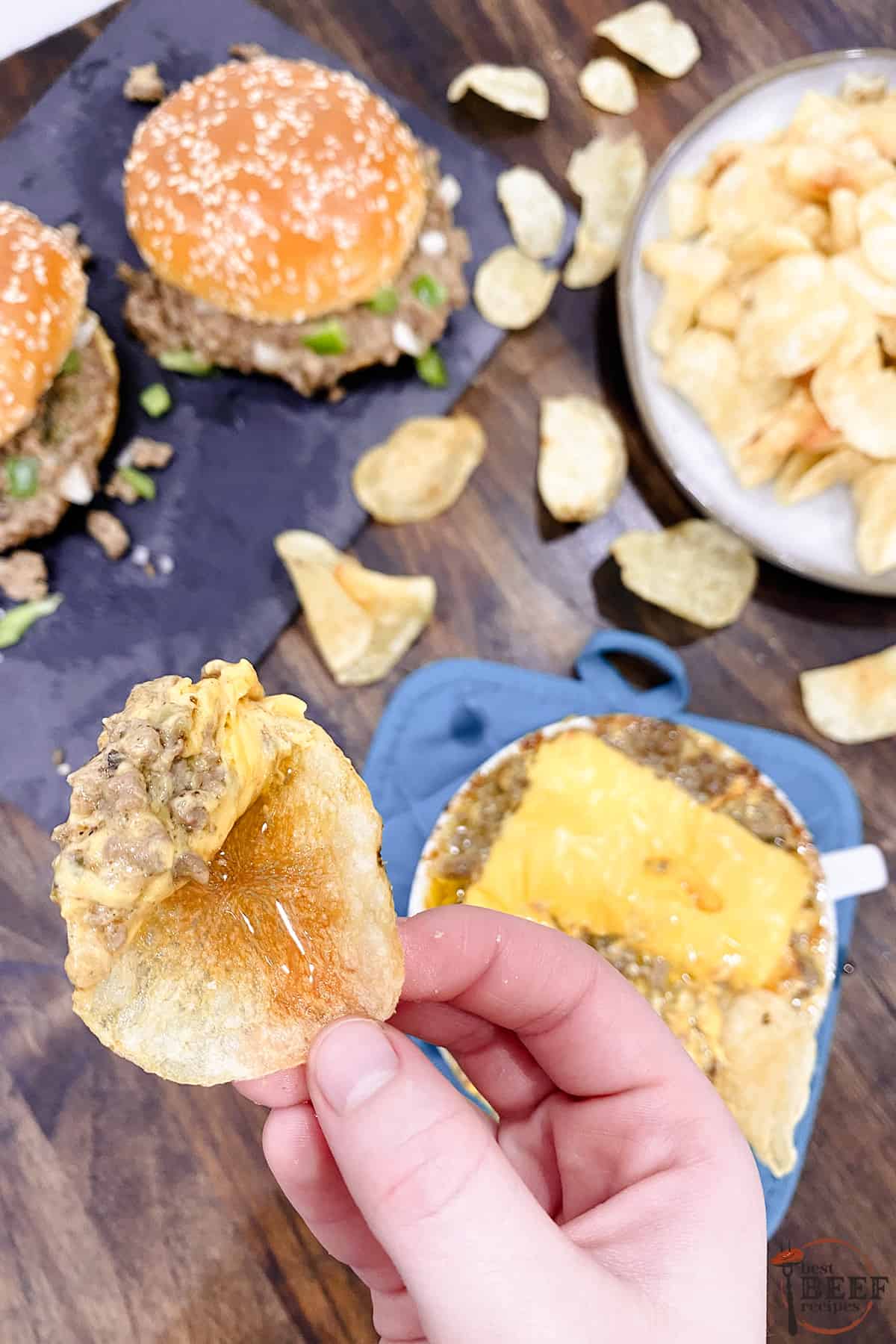 Dipping a chip into the instant pot philly cheese steak dip with cheese on top