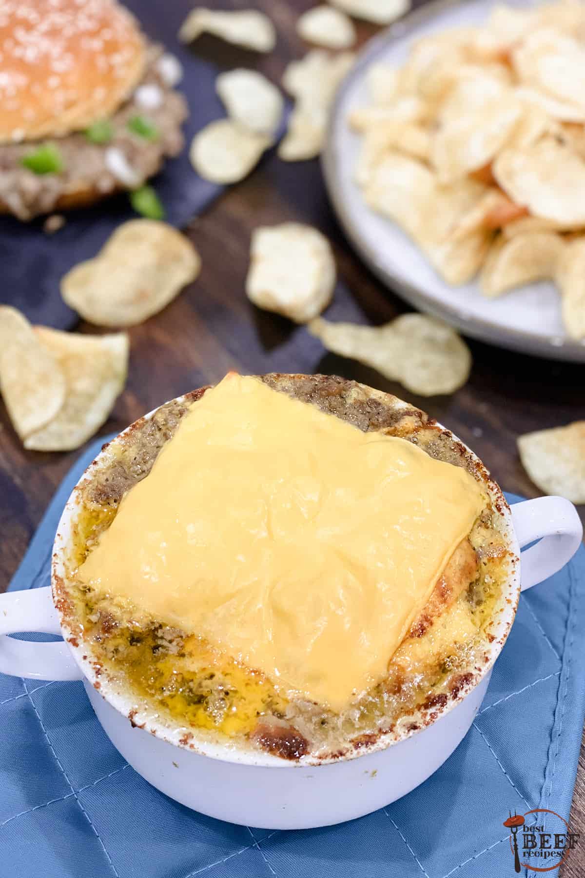 Philly cheese steak dip in a white handled ramekin with a slice of American cheese melted on top