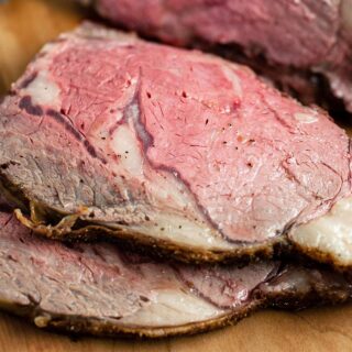 Two slices of prime rib roast on a cutting board