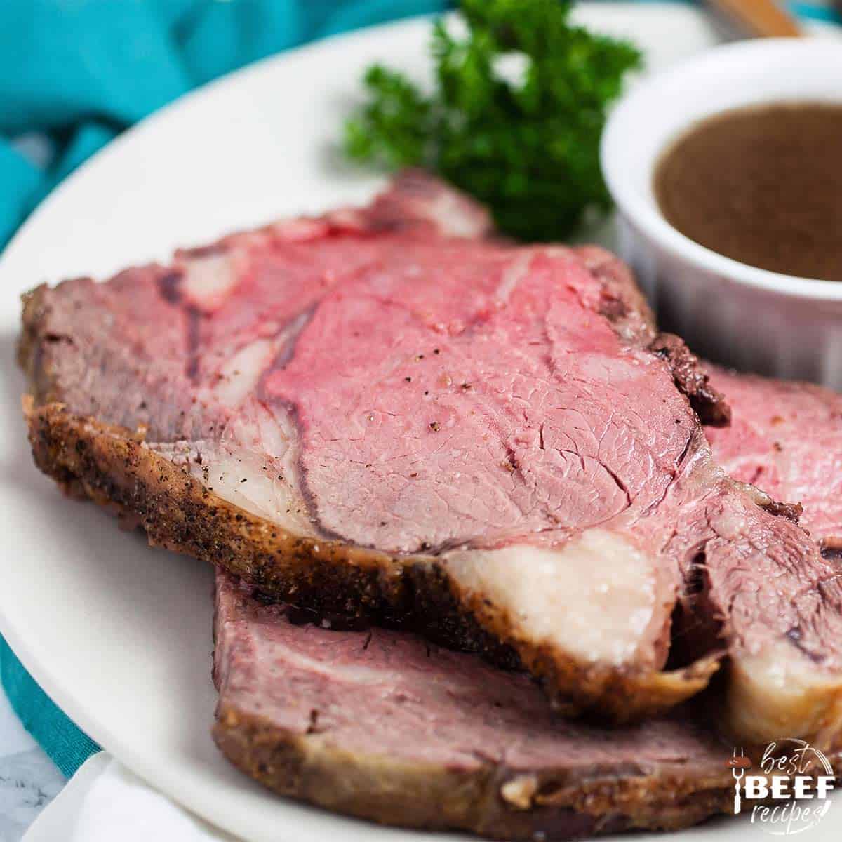 Two slices of boneless prime rib roast on a white plate