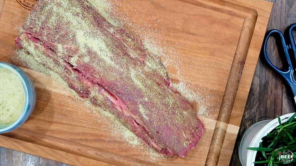 Seasoned beef tenderloin on a cutting board