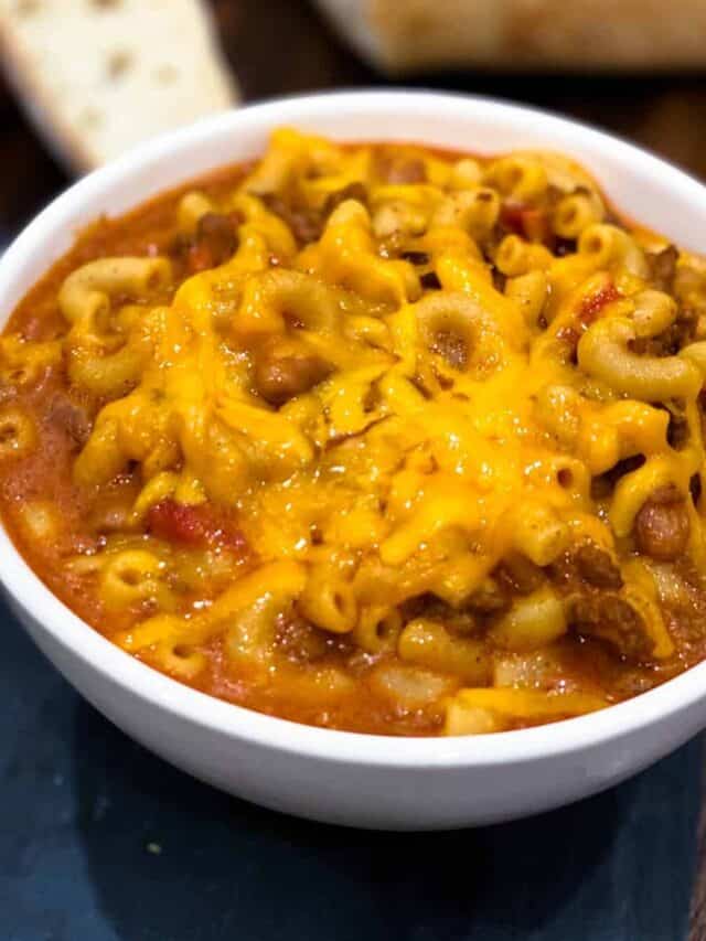 Instant pot chili mac in a white bowl topped with cheese