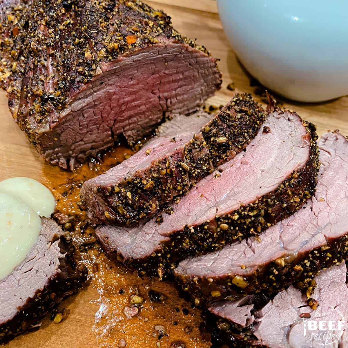 Grilled beef tenderloin sliced on a cutting board