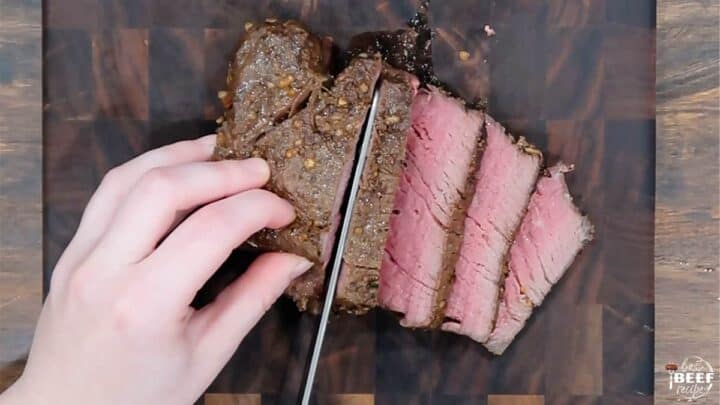 Slicing sous vide filet mignon on a cutting board