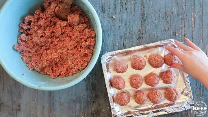 adding meatballs to a foil-lined rack