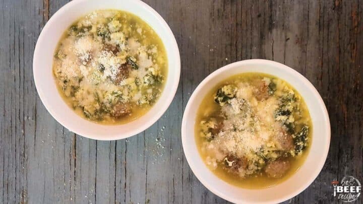 Two bowls of Italian wedding soup topped with Parmesan cheese