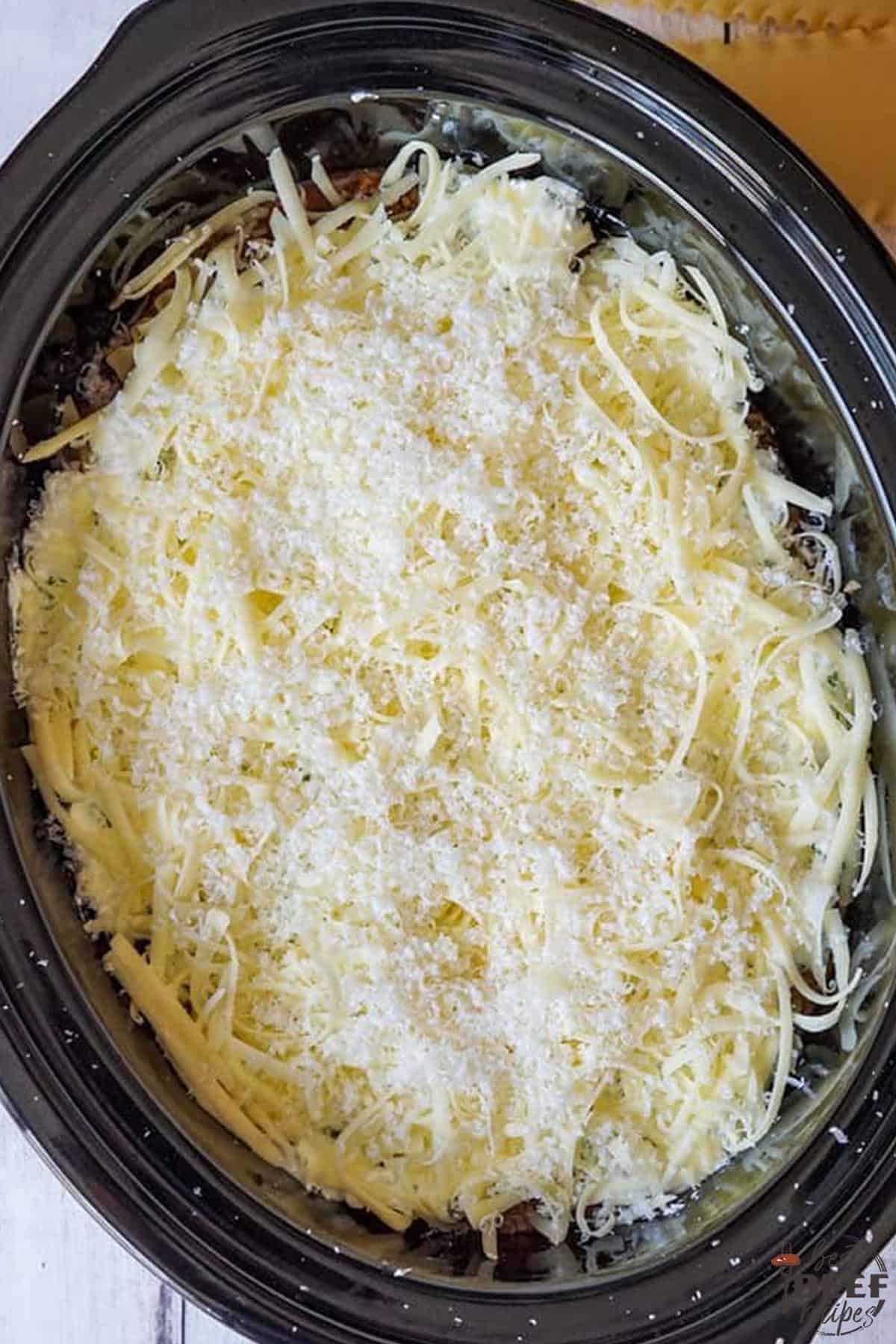A layer of mozzarella cheese in the slow cooker