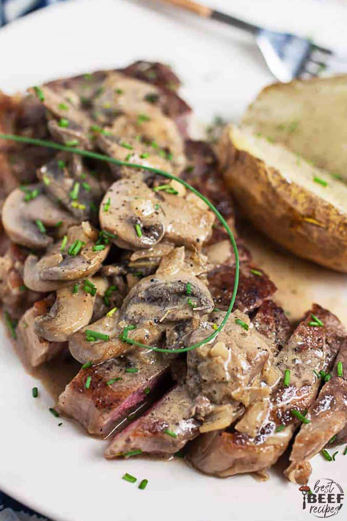 Steak diane on a white plate with potatoes