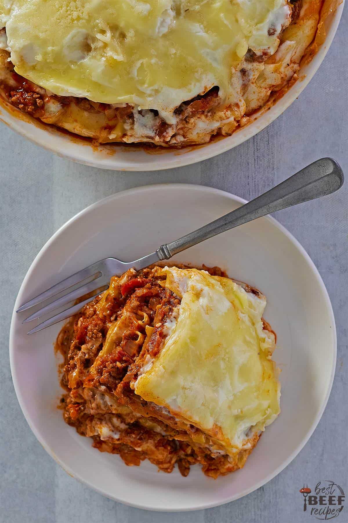 lasagna on a white plate with a fork