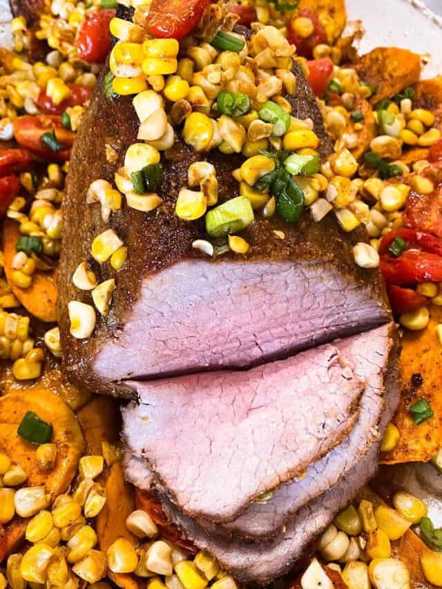 Eye of round roast on a bed of sweet potatoes, tomatoes, and corn