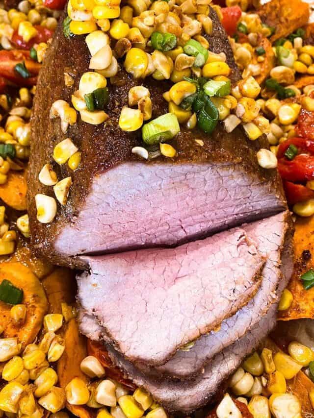 Eye of round roast on a bed of sweet potatoes, tomatoes, and corn