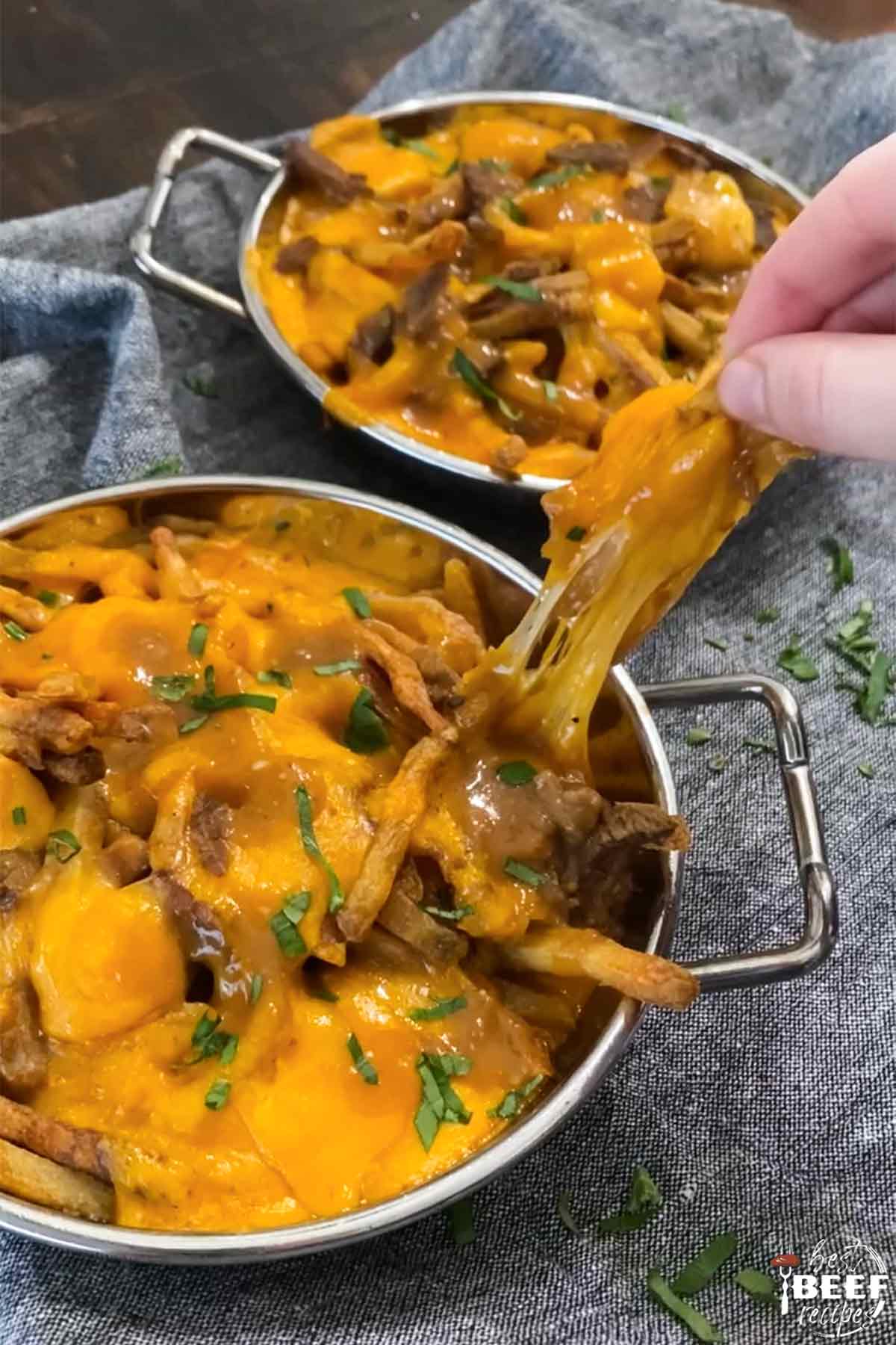 Pulling fry covered in cheese from baking dish 