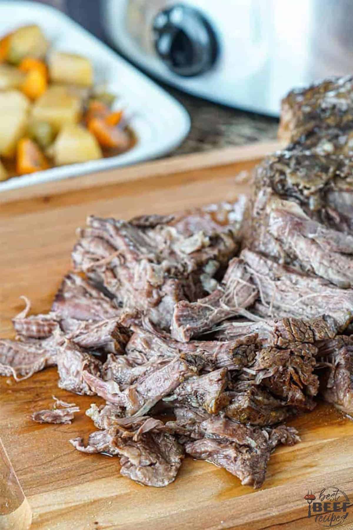 Slow cooker roast beef shredded on cutting board