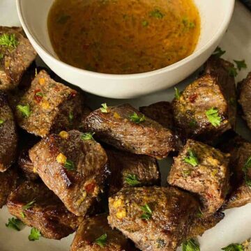 Up close air fryer steak bites with a bowl of cowboy butter