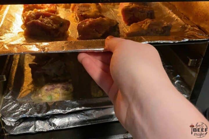 Placing air fryer steak bites into the air fryer on trays