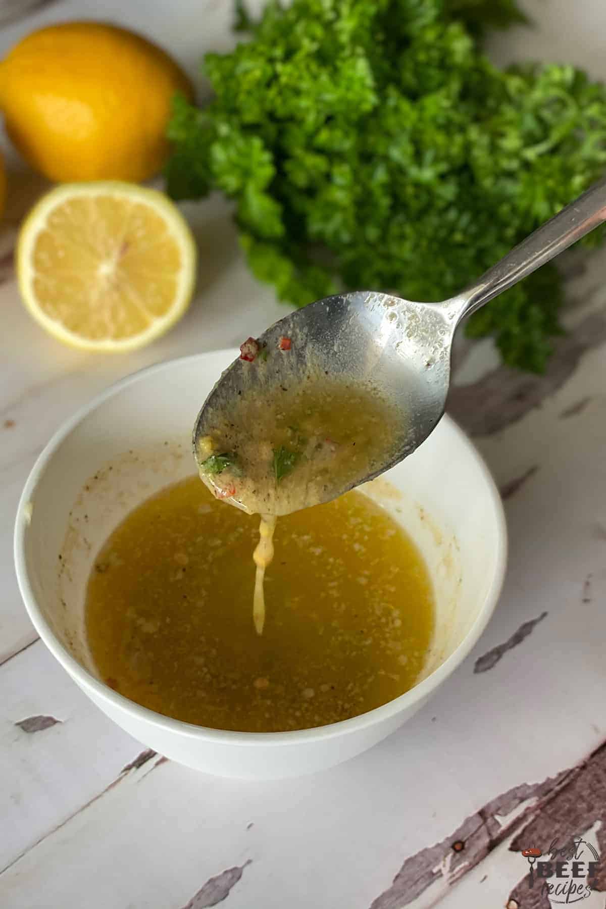 Dripping cowboy butter sauce from a spoon into a bowl