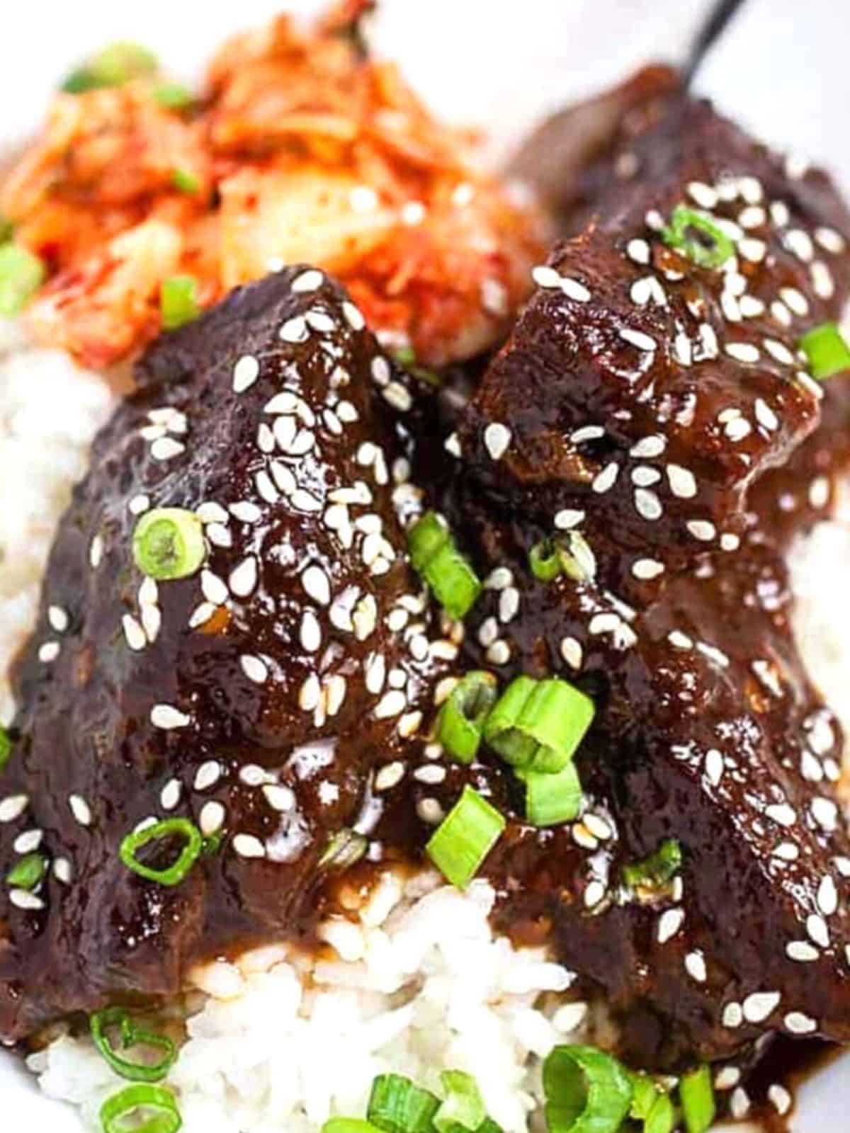 Korean Beef Short Ribs over rice, and topped with green onions.