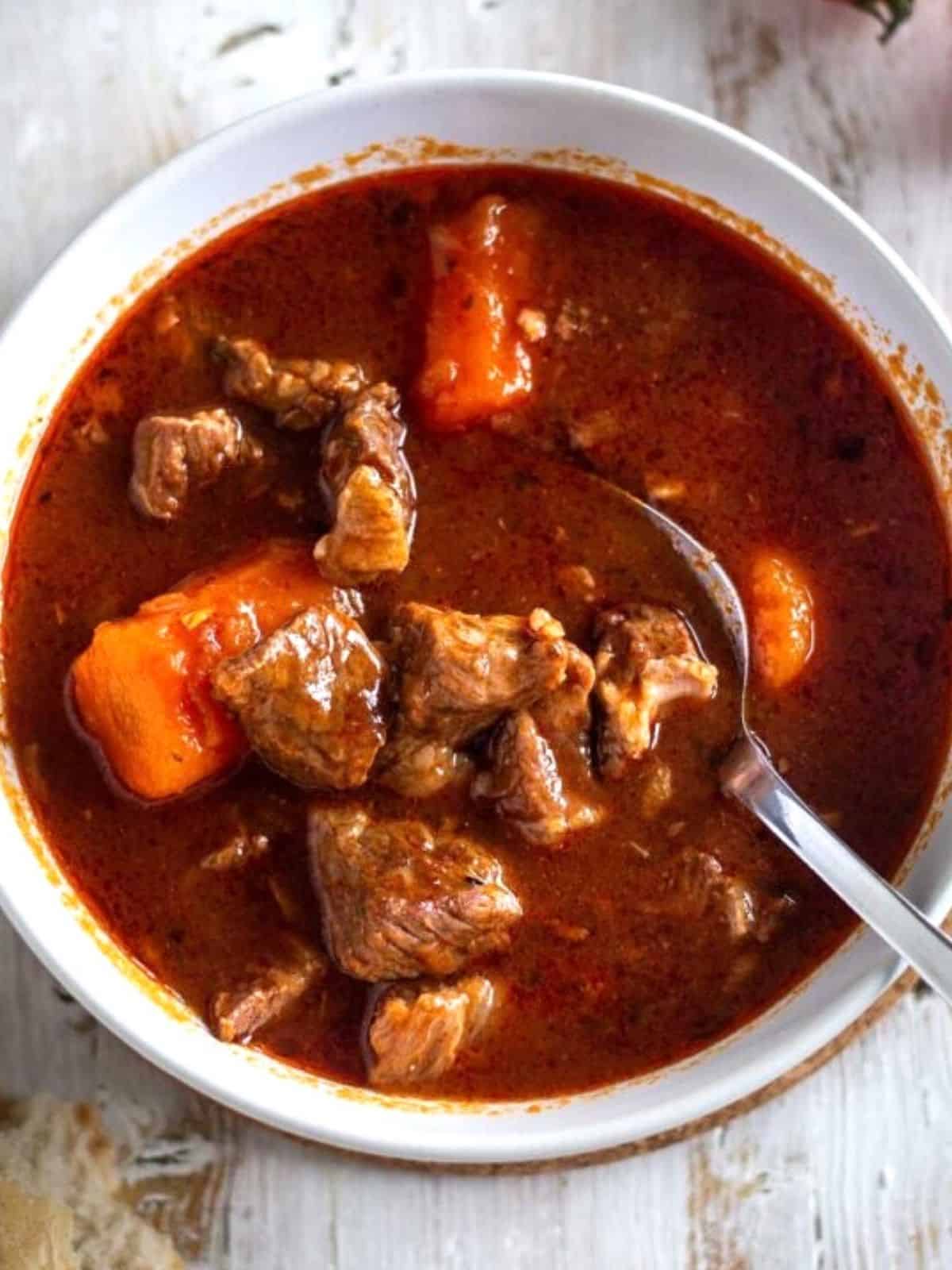 Instant Pot Beef Stew in a white bowl with a spoon