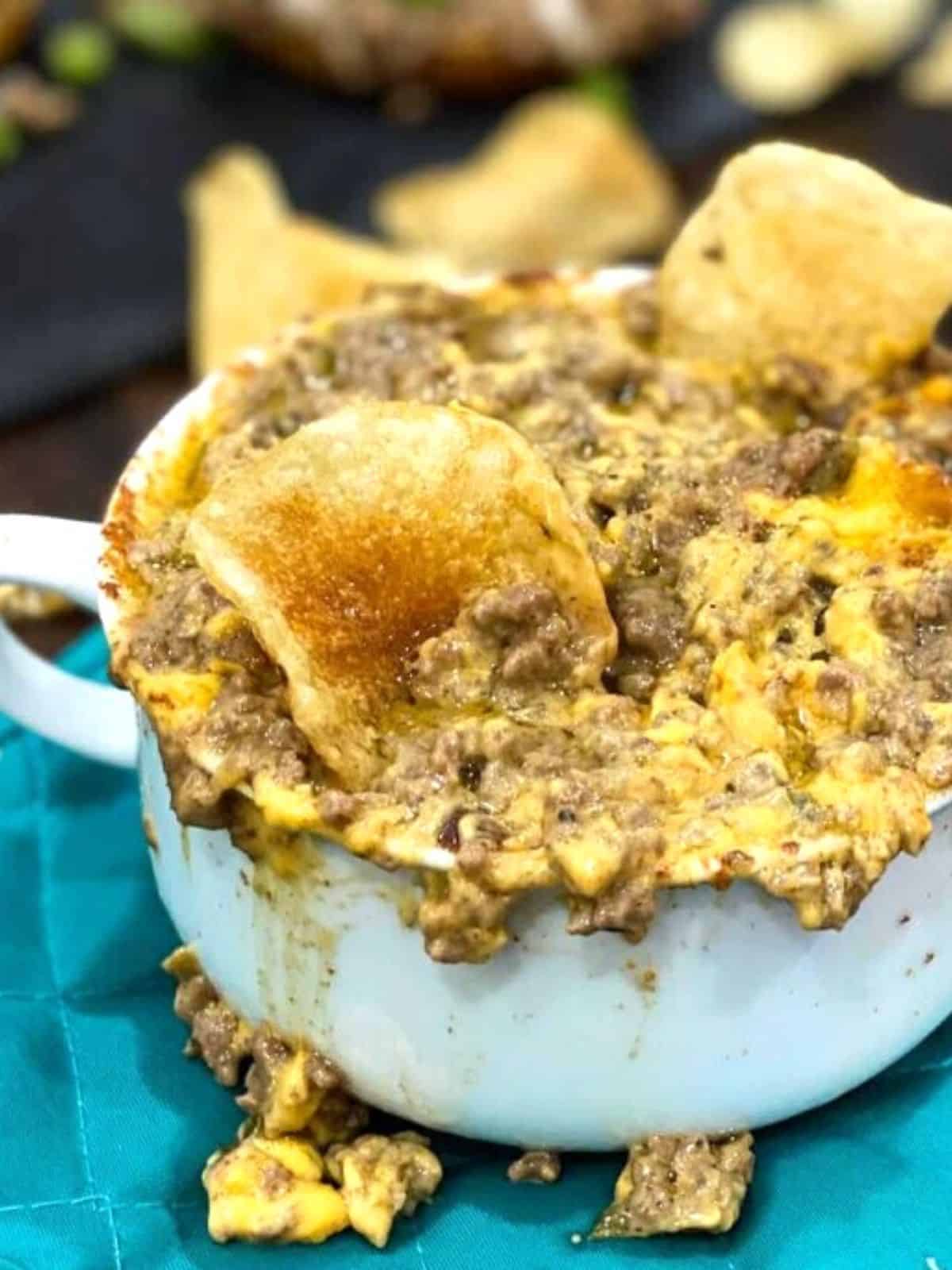 Philly Cheese Steak Dip served in a white cup with potato chips.