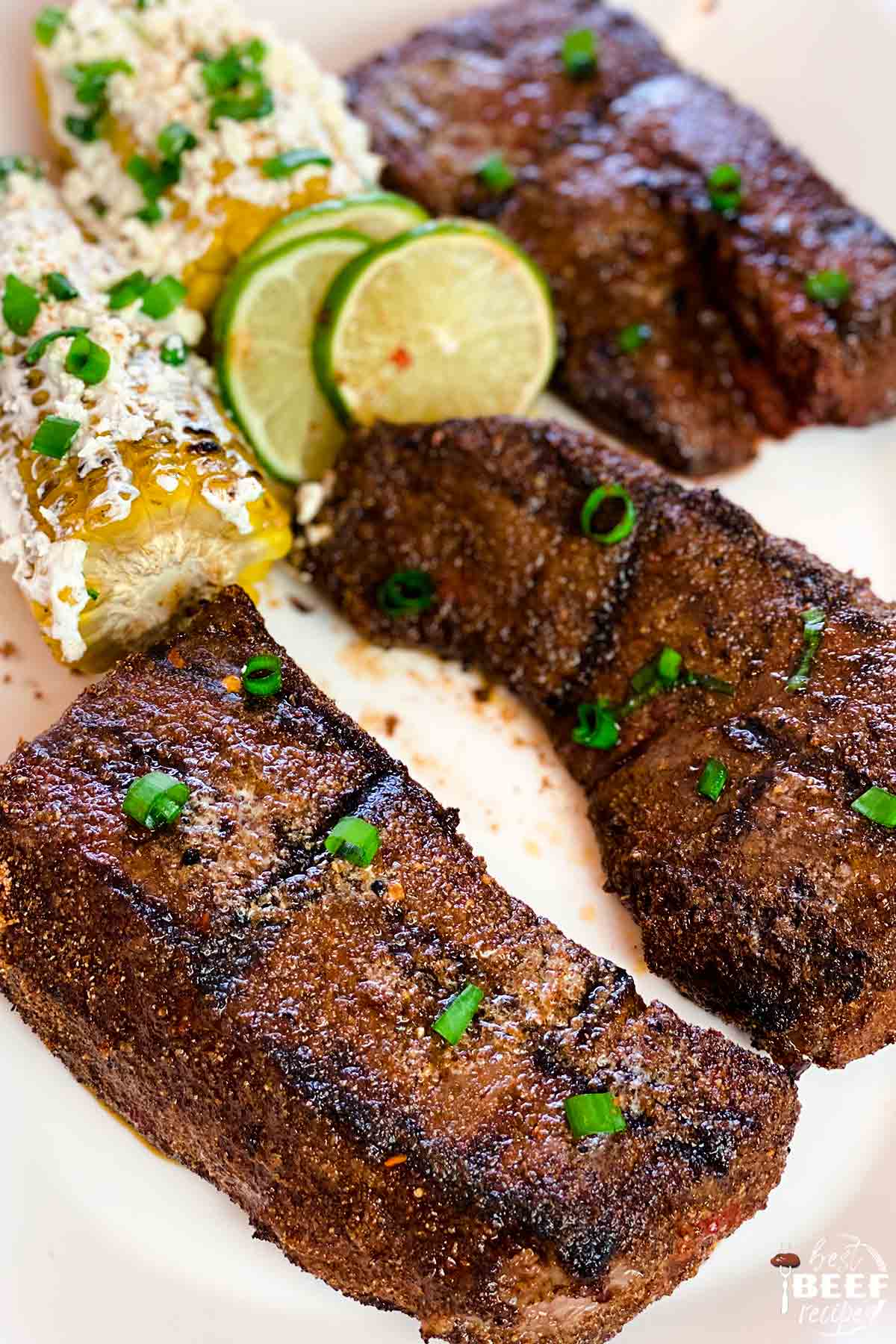 Grilled beef short ribs with corn and lime slices
