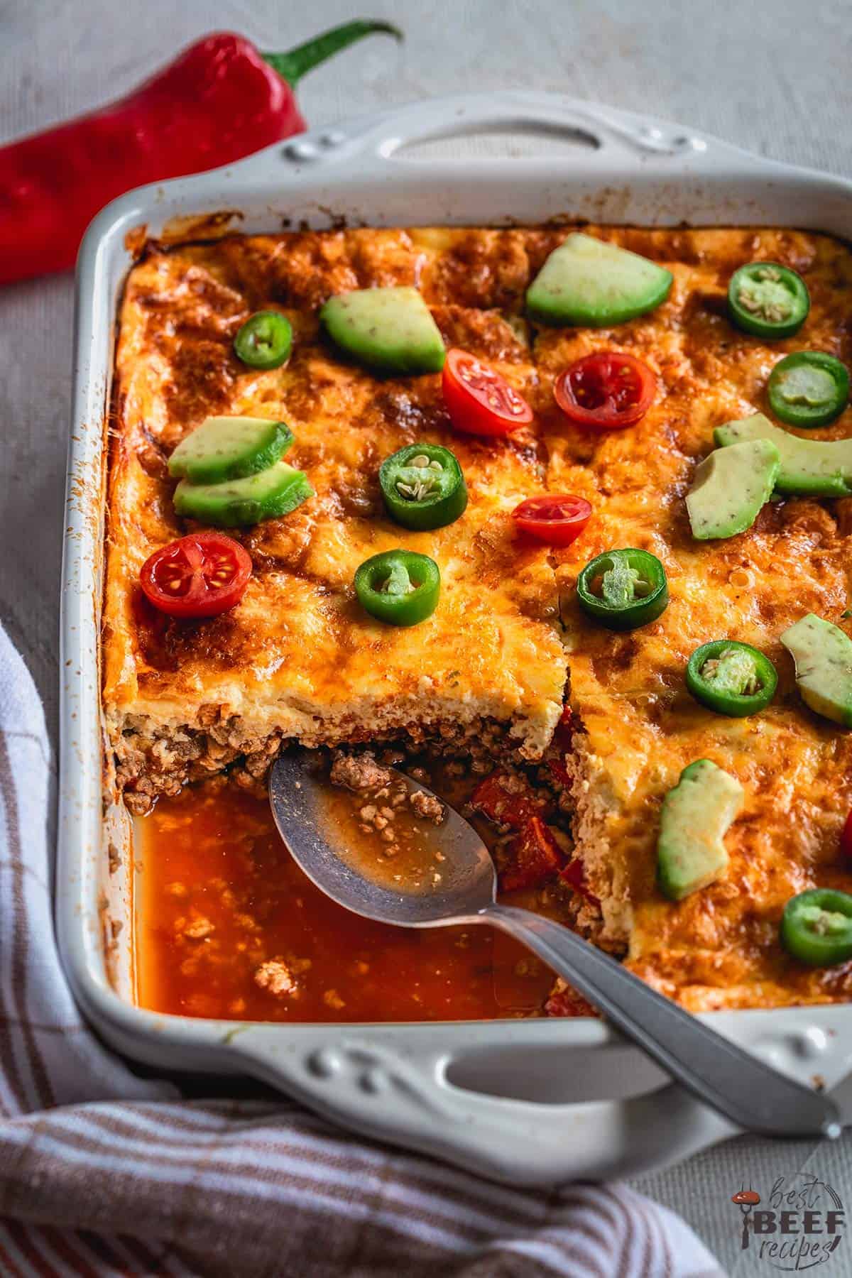 Taco casserole in a dish with a slice missing