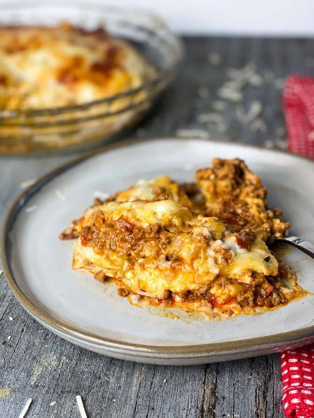 Lasagna served on a white plate.