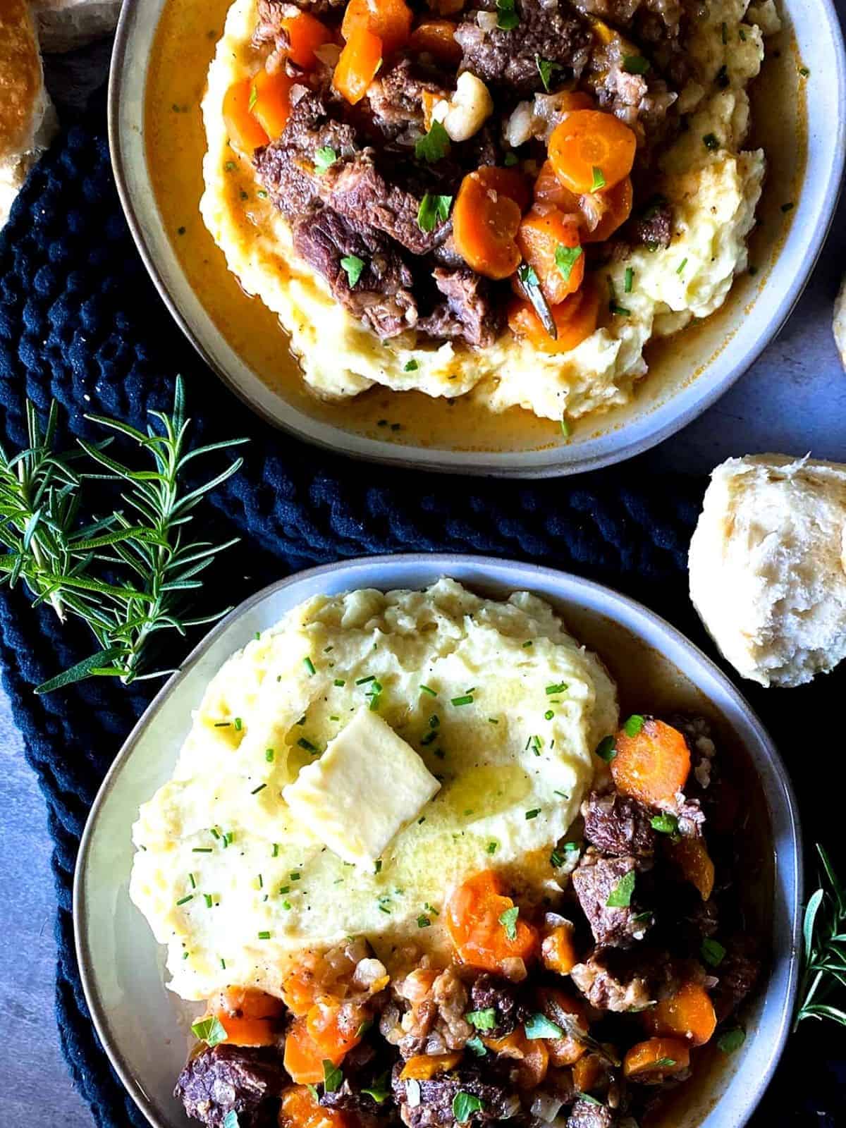 Beef short ribs served with vegetables and mashed potatoes.
