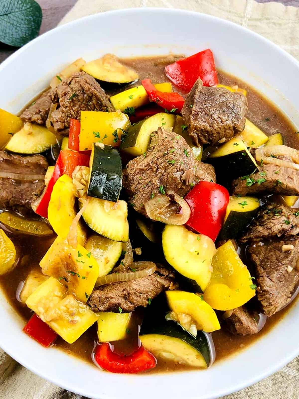 Steak in a stew with diced vegetables.