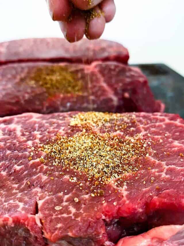 Sprinkling seasoning on steak