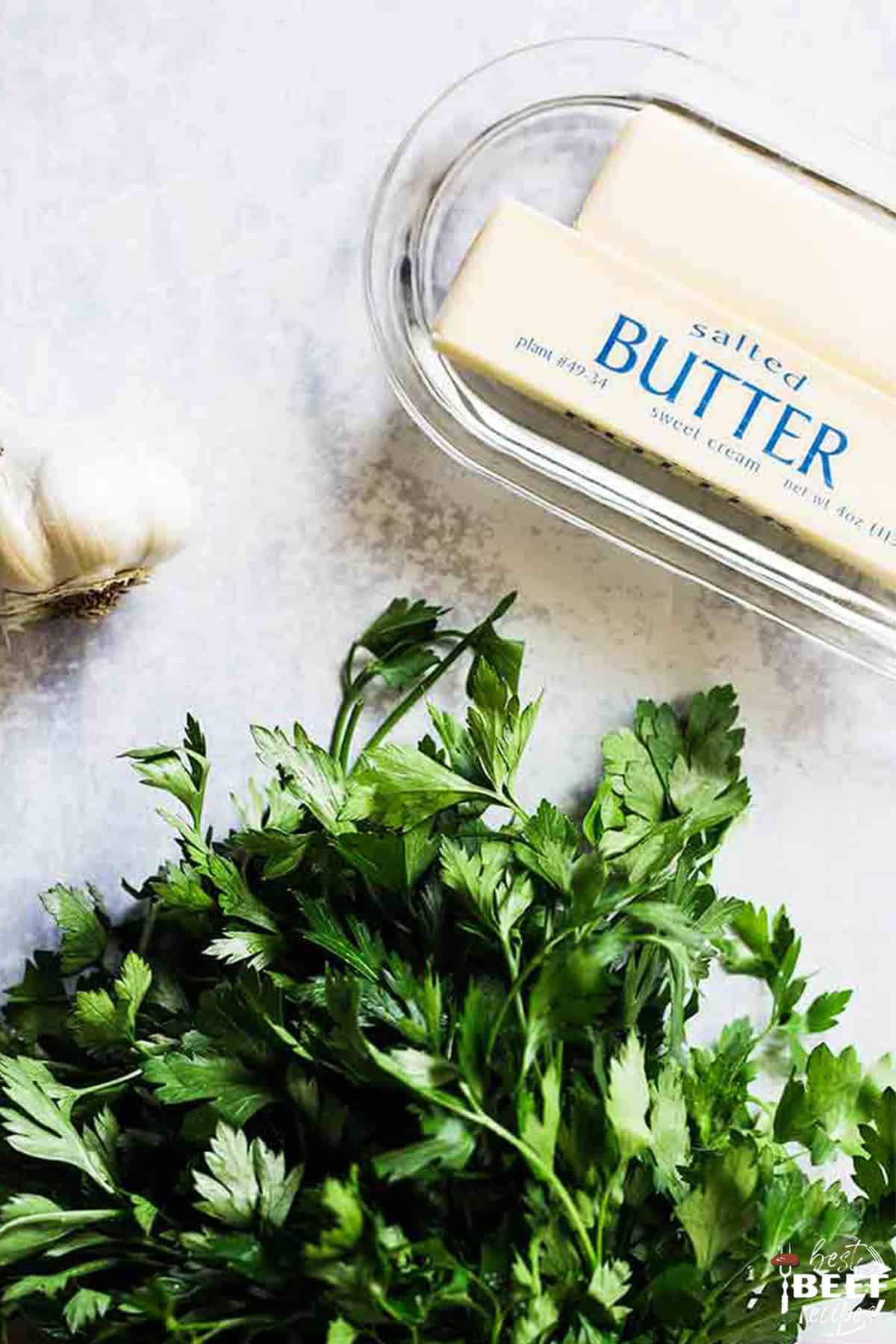 Garlic butter for steaks ingredients on a white surface